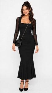 Woman in a textured black midi dress with a wool coat at a winter wedding